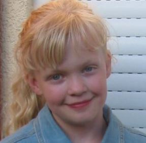 Freya in 2008, portretfoto. Een blond meisje met lang golvend haar in een staart, lichtblauw jeansblouse aan. 